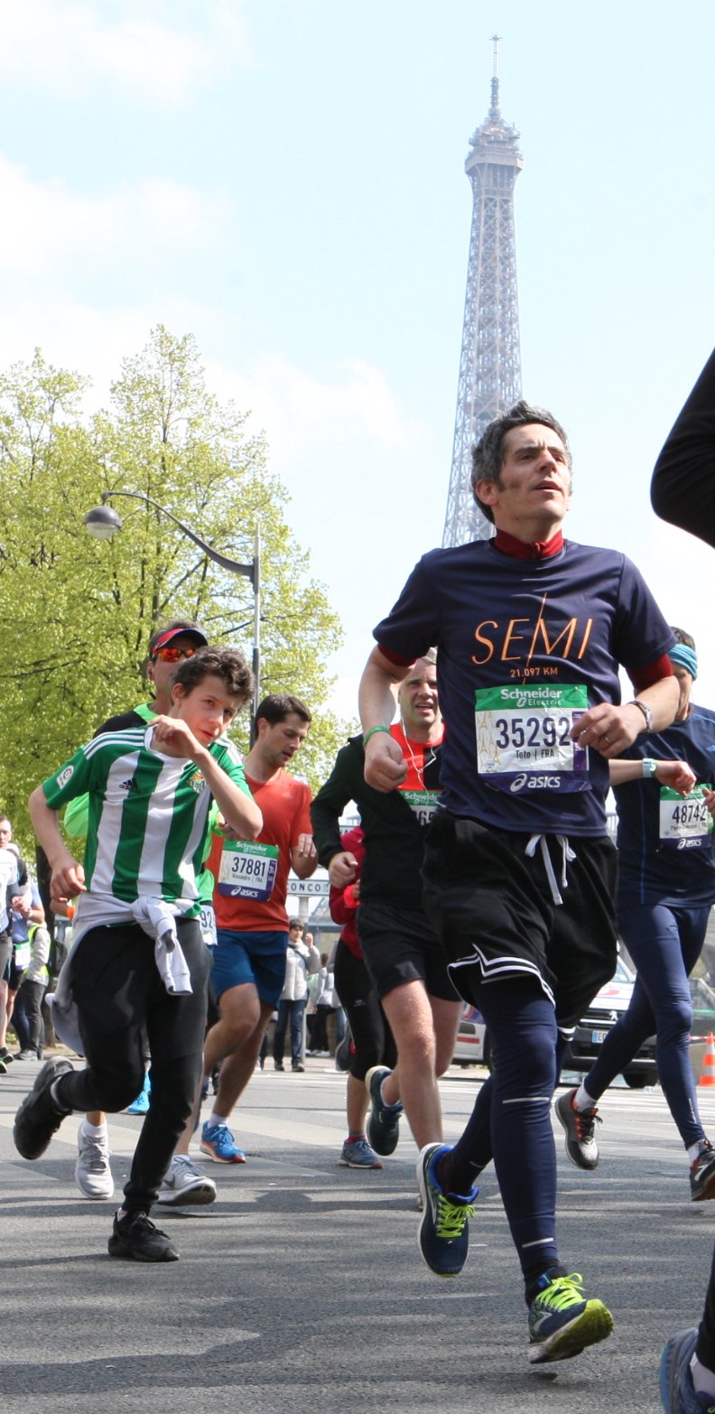 Thomas running in Paris with the Eiffel Tower behind him